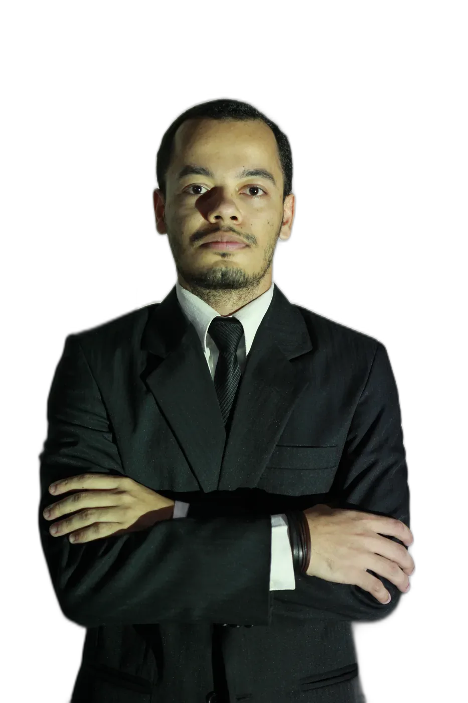 Renan de Almeida, de braços cruzados, em traje escuro